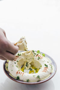 Close-up of hand holding ice cream in bowl