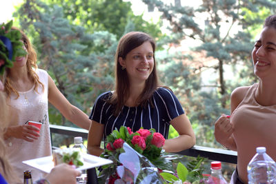 Happy young woman against plants