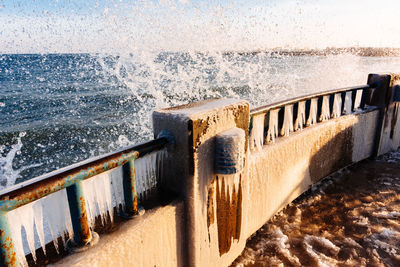 Close-up of wet pier against sky