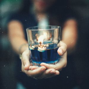 Close-up of hand holding candle