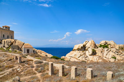 Built structure on beach by sea against sky