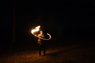 Full length of man playing with fire at night