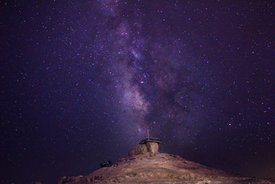 Low angle view of lighthouse against sky at night