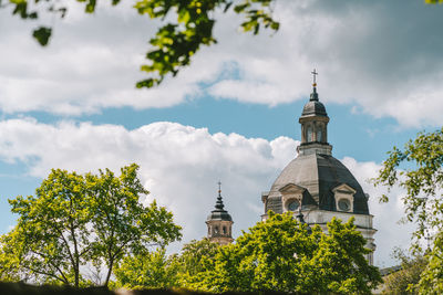 Low angle view of trees and building against sky