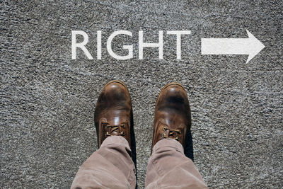 Low section of man standing on road