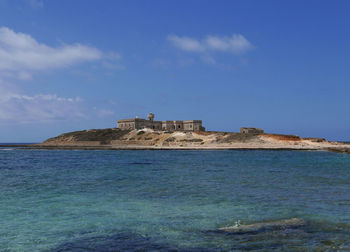 Building by sea against blue sky