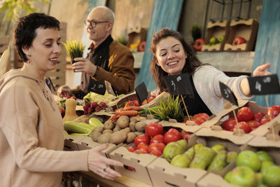 Portrait of smiling friends holding food at home