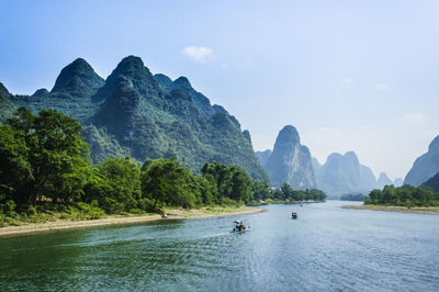 Scenic view of sea and mountains against sky