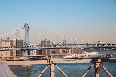 Manhattan bridge over east river against clear sky in city