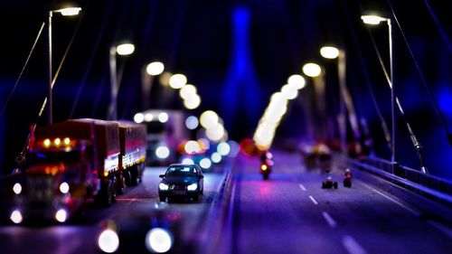Tilt-shift image of vehicles on illuminated bridge