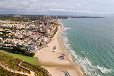 High angle view of townscape by sea against sky