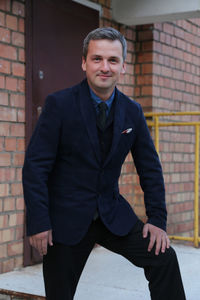 Portrait of businessman standing against wall