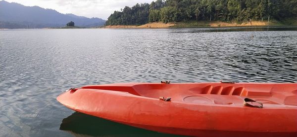 Boat moored on lake against mountain