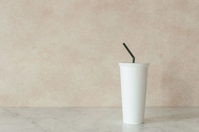 Close-up of drink on table against wall