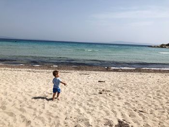 Boy on beach against sky