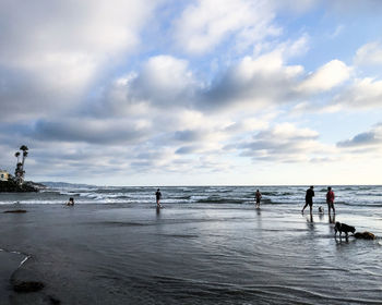 People on beach against sky