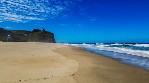 Scenic view of beach against blue sky