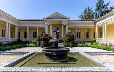 Fountain in front of building against clear sky