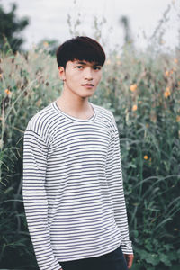 Portrait of young man standing against plants