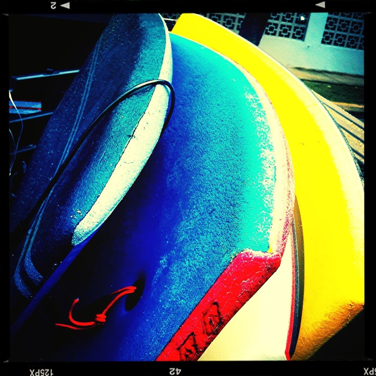 transfer print, auto post production filter, blue, yellow, high angle view, transportation, close-up, no people, outdoors, mode of transport, day, multi colored, part of, sunlight, communication, cropped, text, western script, sport, absence