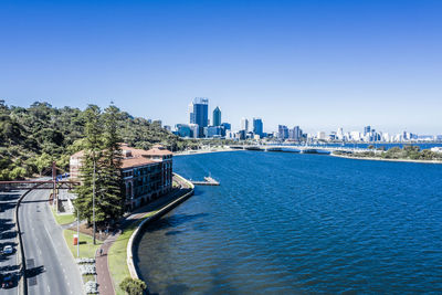 Panoramic view of buildings in city against clear blue sky