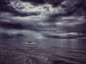 Scenic view of sea against storm clouds