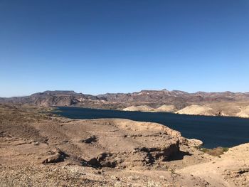 Scenic view of desert against clear blue sky