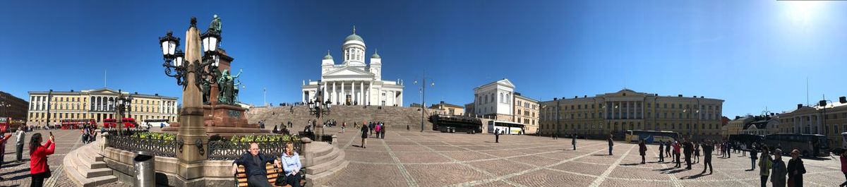 Buildings in city against clear blue sky