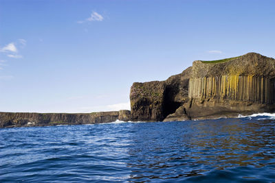 Built structure by sea against blue sky