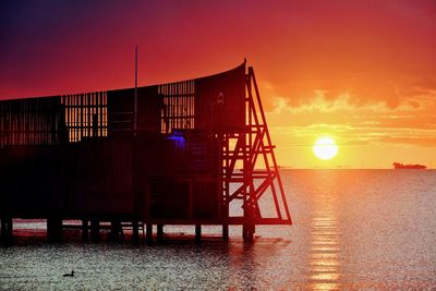 Scenic view of sea against orange sky