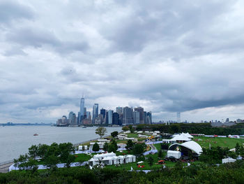 Buildings in city against cloudy sky