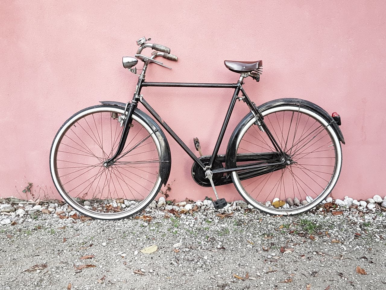 HIGH ANGLE VIEW OF BICYCLE PARKED BY PINK WALL