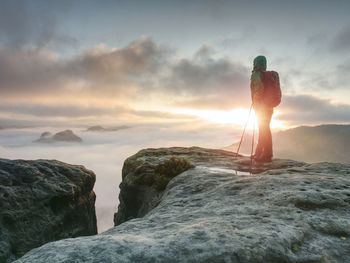 View from sharp cliff into mystery misty landscape. woman enjoy the deep silence.
