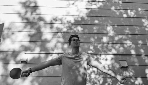 Full length of young man standing against wall