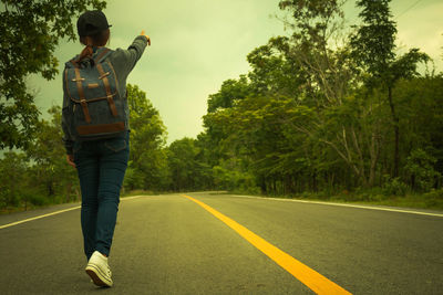 Rear view of man standing on road