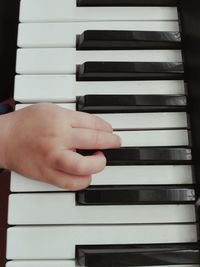 Close-up of hands playing piano