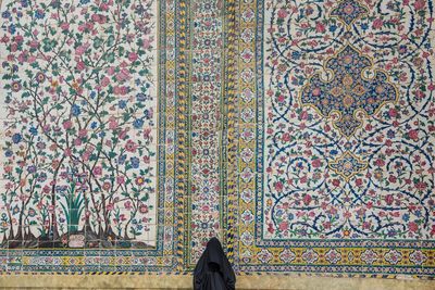 Low section of woman standing against multi colored wall