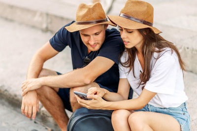 Tourists looking at smartphone screen and choose a hotel. couple of tourists on vacation in rome