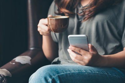 Midsection of woman using mobile phone