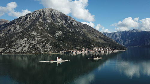 Scenic view of lake by mountains against sky