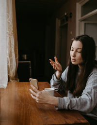 Young woman using mobile phone at home