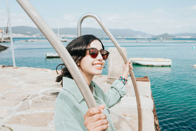 Young woman standing at harbor