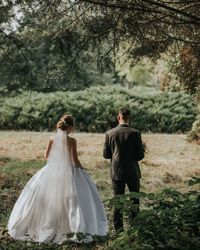 Rear view of couple kissing against trees