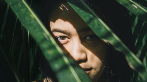 Portrait of teenage girl under the shadow of leaves