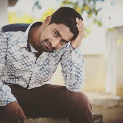 Portrait of young man sitting outdoors