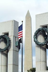 Low angle view of flags on building against sky