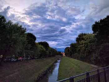 Road amidst trees against sky