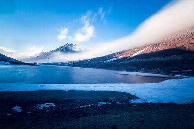 Scenic view of snowcapped mountains against blue sky during winter