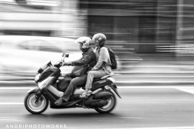 Side view of a man riding motorcycle on road