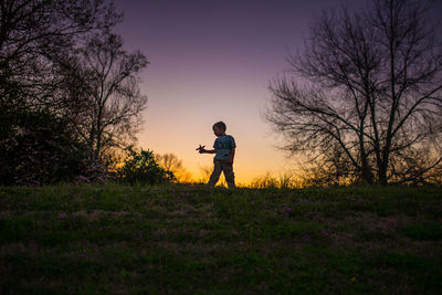 Little boy playing airplane silohette summer sunset purple yellow